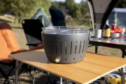 LotusGrill XL Hybrid Houtskoolbarbecue - Zwart -Zwembad Tuin lotusgrill in zon op tafel 1 1