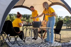 LotusGrill XL Hybrid Houtskoolbarbecue - Zwart -Zwembad Tuin sfeerfoto met meerdere shirtjes